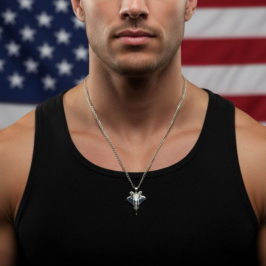 Silver-plated F-22 Raptor Fighter Jet Necklace worn by model with American Flag background. Premium Aviation Jewelry & Pilot Gift.